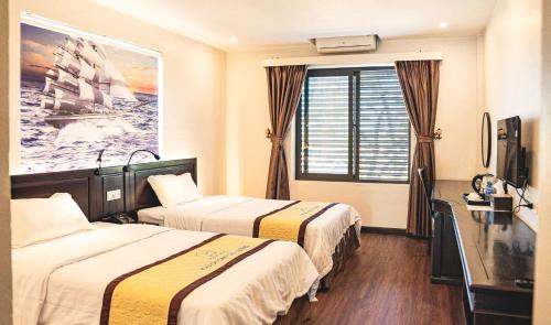 a hotel room with two beds and a window at Khách sạn Đại Dương Diễn Châu - Nghệ An in Diễn Châu