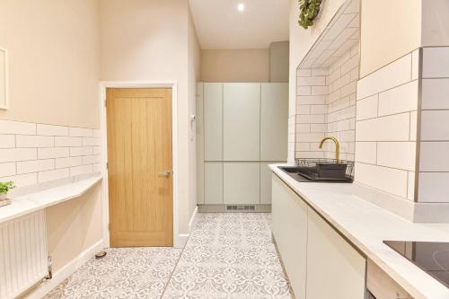 惠特利灣的住宿－Modern Luxury 2-bedroom Oasis In Heart Of Whitley，一个带水槽和木门的厨房