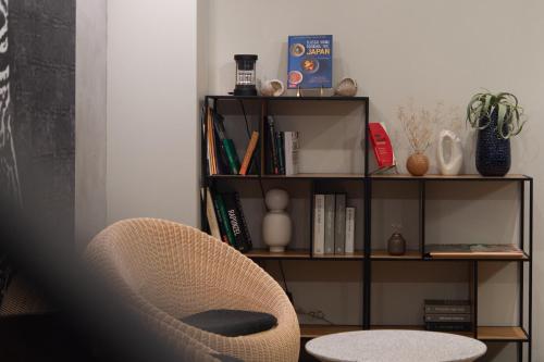 a room with a chair and a book shelf at Design Hotel Kyoto Fuyacho in Kyoto