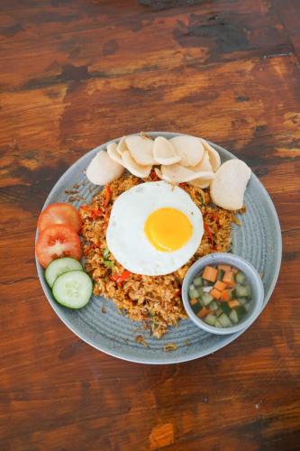 a plate of food with an egg on top at Puri Tempo Doeloe Boutique Hotel in Sanur