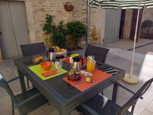 stół z jedzeniem i parasolką w obiekcie Room in Guest room - Decouvrez un sejour relaxant a Meursault, en France w mieście Meursault