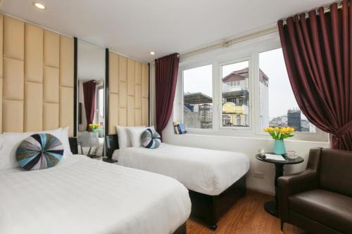 um quarto de hotel com duas camas e uma janela em Splendid Holiday Hotel Spa em Hanói