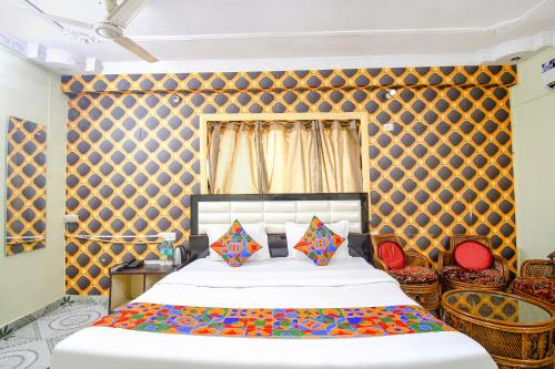 1 dormitorio con 1 cama grande y almohadas coloridas en FabHotel Golden Horizon en Ranchi