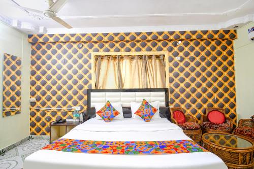 um quarto com uma cama grande e almofadas coloridas em FabHotel Golden Horizon em Ranchi