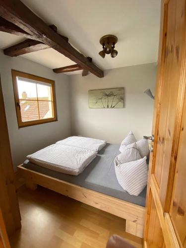 a bedroom with a bed with white sheets and a window at Ferienhaus Leuchtturm in Fehmarn