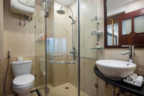 a bathroom with a shower and a toilet and a sink at Splendid Holiday Hotel Spa in Hanoi