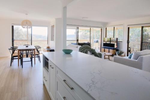 a kitchen and living room with a table and chairs at Bayview Oasis- With pool in Hardys Bay