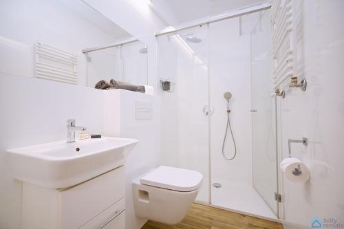 a white bathroom with a sink and a shower at Bianco by 3City Rentals in Sopot