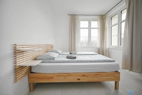 a bedroom with a large bed in a room with windows at Bianco by 3City Rentals in Sopot