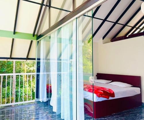 a bedroom with a bed and a large window at River zone villa in Meppādi