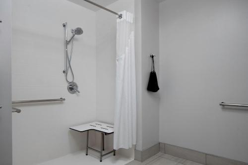 a white bathroom with a shower curtain and a stool at Holiday Inn Express & Suites Griffin in Griffin
