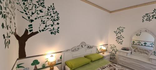 a bedroom with a tree mural on the wall at I Sollazzi in Palermo