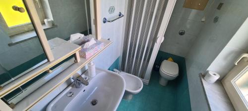 a bathroom with a sink and a toilet and a mirror at I Sollazzi in Palermo