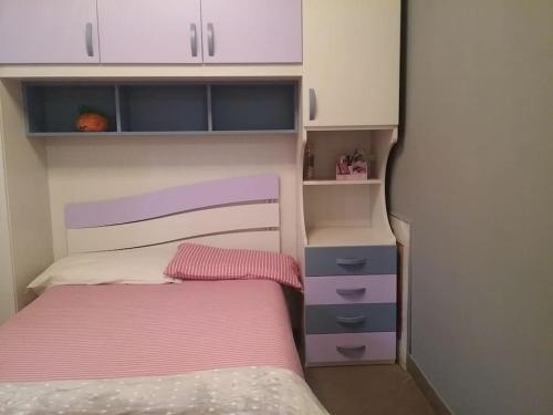 um pequeno quarto com uma cama e um armário em Appartamento Super Confortevole em Gaglianico