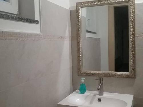 a bathroom with a white sink and a mirror at Appartamento Super Confortevole in Gaglianico