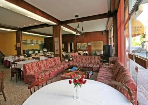 オ・グローベにあるHotel Angelitoのソファと花のテーブルが備わる広い客室です。