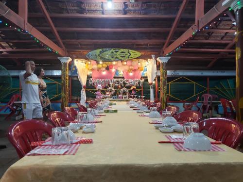 a long table in a room with red chairs at Long Vĩ hotel - đảo Phú Quý in Cu Lao Thu