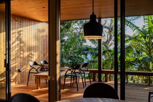 a dining room with a table and chairs and a large window at ガーデンヴィラ白浜　KOTI in Shimoda
