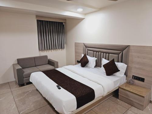 艾哈邁達巴德的住宿－HOTEL R K VILLA，一间卧室配有一张大床和一张沙发