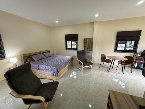 1 dormitorio con cama, sillas y mesa en Vergers de Nil les lauriers 