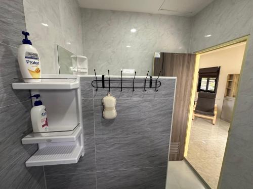a bathroom with a soap dispenser on the wall at Vergers de Nil les lauriers in Ban Chawuk