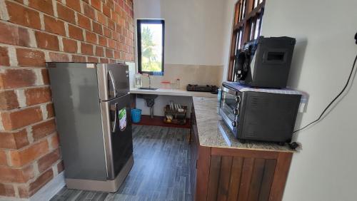 a kitchen with a refrigerator and a tv on a counter at BB GUESTHOUSE in Ambalangoda