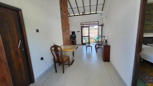 a hallway with a table and chairs in a room at BB GUESTHOUSE in Ambalangoda
