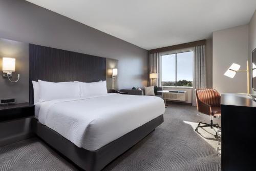 a hotel room with a large bed and a desk at Holiday Inn Carlsbad/San Diego by IHG in Carlsbad