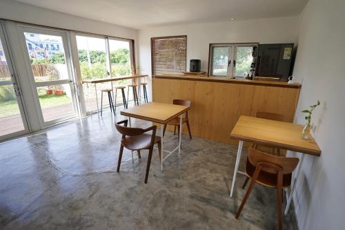 a room with two tables and chairs and windows at 花矸571民宿 HuaGan571 in Xiaoliuqiu