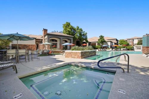 a swimming pool with a table and chairs in a resort at Champion's CozySuite walk to the stadium with pool! in Glendale