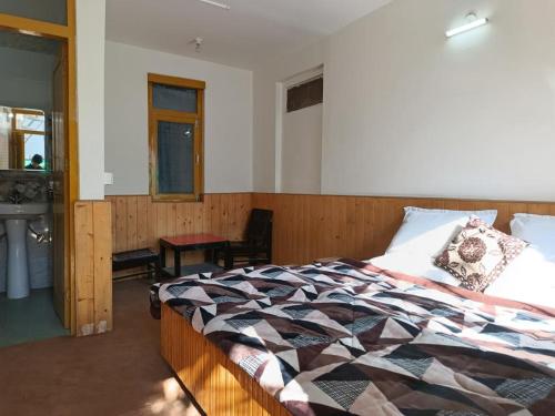 - une chambre avec un lit et un lavabo dans l'établissement iSaint's Kuteer, à Manali