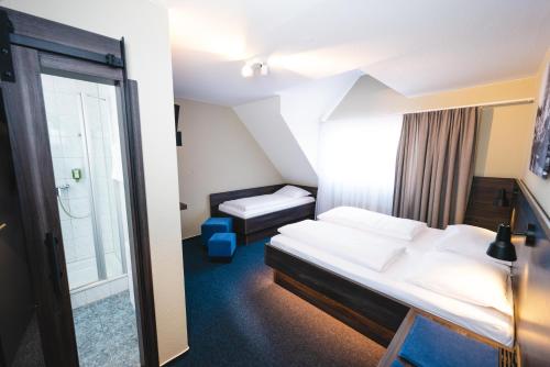 a hotel room with a bed and a bathroom at Hotel am Park in Rust