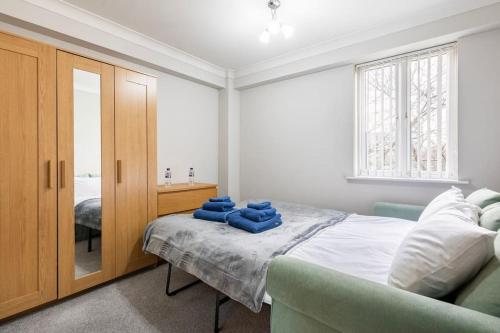 a bedroom with a bed with blue towels on it at Beautiful 2 bed / 2 bath flat near central London in London