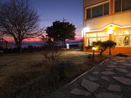 una casa con un sentiero di pietra davanti di notte di Canada Mung Village a Yeosu
