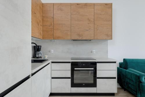a kitchen with white cabinets and a black oven at Modern Apartment 1 Maja with Parking in Kołobrzeg by Rent like home in Kołobrzeg
