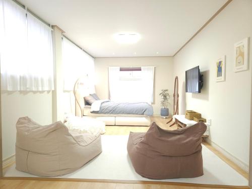 sala de estar con 2 sillas y 1 cama en Canada Mung Village, en Yeosu