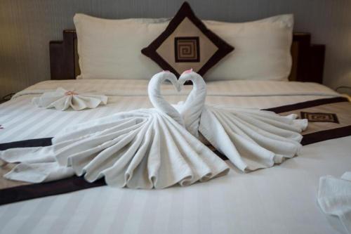 two white swansrendered to look like they are kissing on a bed at Splendid Holiday Hotel Spa in Hanoi