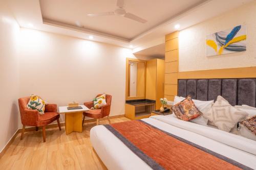 a hotel room with a bed and a table and chairs at Super Hotel by Perfectstayz Mall Road in Mussoorie