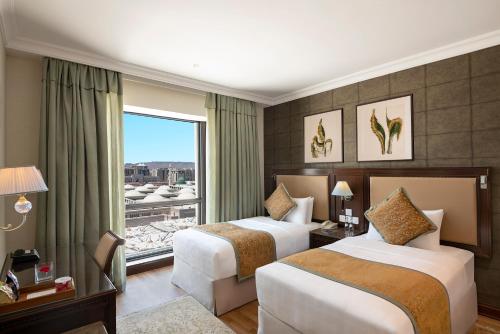 メディナにあるThe Oberoi Madina المدينة أوبرويのベッド2台と窓が備わるホテルルームです。