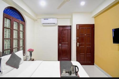 1 dormitorio con 1 cama y 2 puertas de madera en Hotel Jheel Mahal New Town Inn West Bengal - Couple Friendly en Jojera