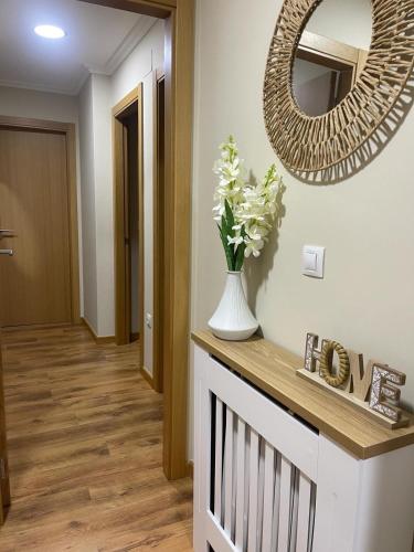 a hallway with a mirror and a vase with flowers at Rincon Talo Río in Arcade