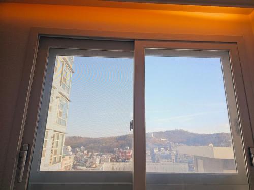 a window with a view of a city at Gamseong house #Gimpo airport 10 min #Hwagok station #Netflix #Beamprojet #niceview in Seoul