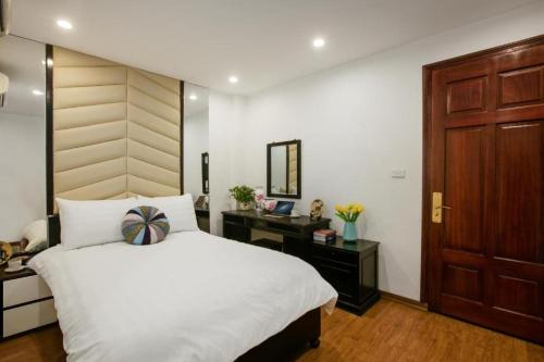 a bedroom with a bed and a desk and a mirror at Splendid Holiday Hotel Spa in Hanoi