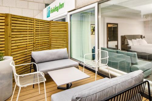 a room with couches and chairs and a bed at Holiday Inn Milton Keynes Central by IHG in Milton Keynes