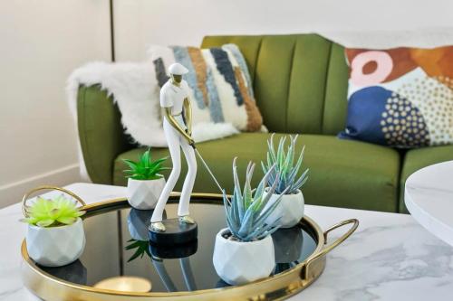 a mannequin on a table in a living room with plants at CozySuites Glendale by the stadium with pool 02 in Glendale