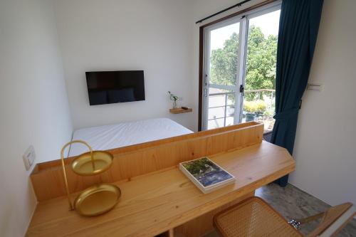 a bedroom with a bed and a desk with a television at 花矸571民宿 HuaGan571 in Xiaoliuqiu