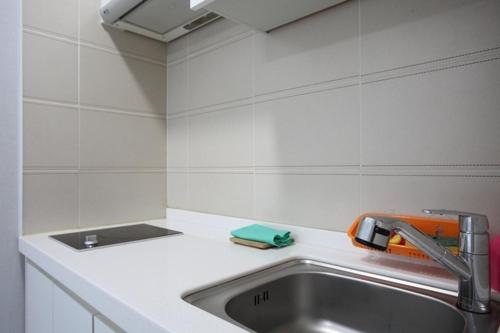 a kitchen counter with a sink and a faucet at Poem House in Jeju