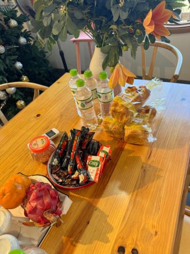 a wooden table with a plate of food and drinks at En nho Homestay SaPa in Sa Pa