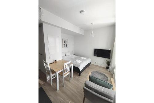 a living room with a table and a bed and a couch at Kotimaailma Apartments Oulu in Oulu