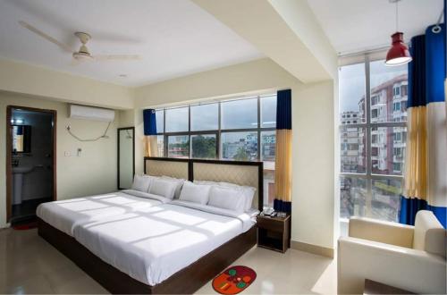 una camera con un grande letto e una grande finestra di New Hotel Grand View a Sylhet